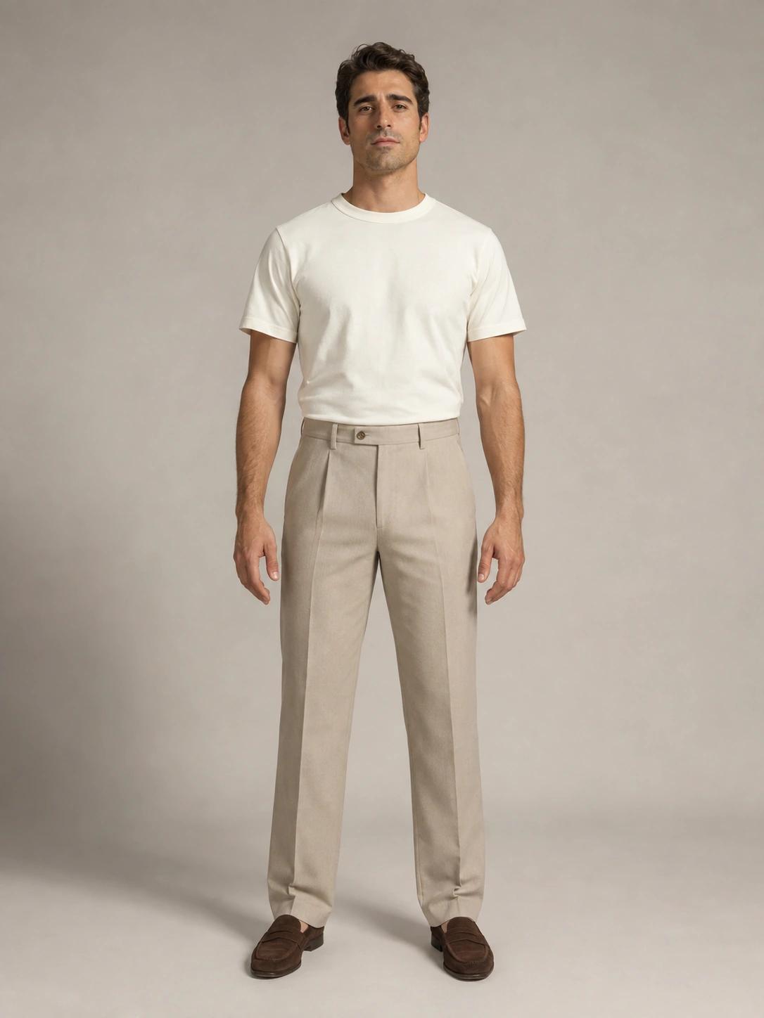 The FIT model in an ivory crew-neck T-shirt, stone pleated trousers and brown suede loafers.